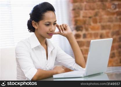 Businesswoman in office with laptop