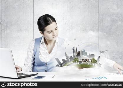 Businesswoman in process of work. Young attractive businesswoman working at her desk with laptop and construction project