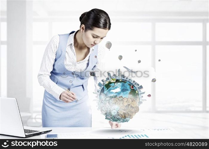 Businesswoman in process of work. Young attractive businesswoman working at her desk with laptop and papers. Elements of this image are furnished by NASA