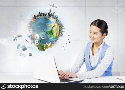 Businesswoman in process of work. Young attractive businesswoman working at her desk with laptop and papers. Elements of this image are furnished by NASA
