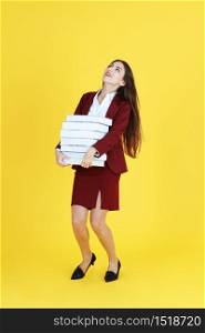 Businesswoman in red suit hand holding document books isolated on yellow background. Copy Space