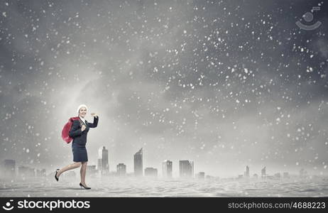 Businesswoman in Santa hat. Santa woman running with red gift bag on back