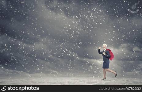 Businesswoman in Santa hat. Santa woman running with red gift bag on back