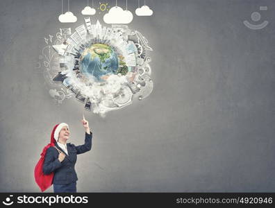 Businesswoman in Santa hat. Santa woman running with red gift bag on back. Elements of this image are furnished by NASA