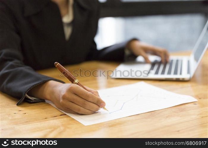 businesswoman in suit analyze with market analysis business chart document with computer laptop