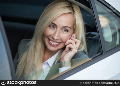 Businesswoman inside her car using a mobile phone