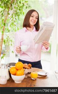 Businesswoman is reading newspaper during a breakfast