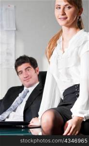 businesswoman is sitting on table at office with her boss in chair