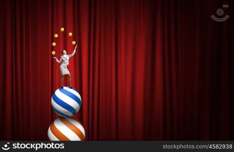 Businesswoman juggling with balls. Young businesswoman standing on ball juggling with balls