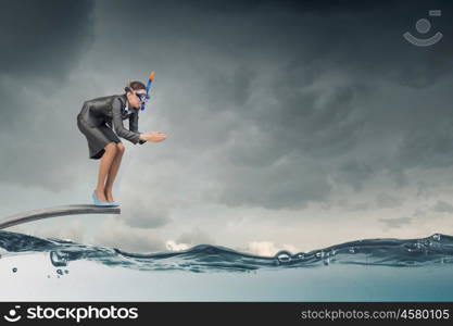 Businesswoman jumping in water. Businesswoman in suit and mask jumping from springboard