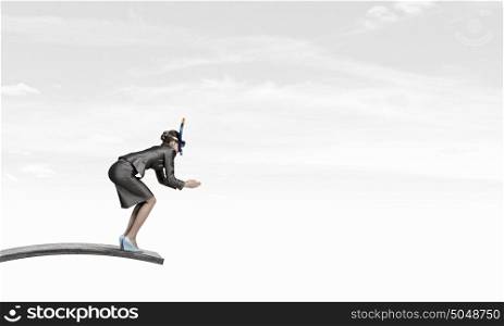 Businesswoman jumping in water. Businesswoman in suit and mask jumping from springboard