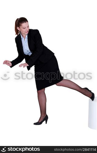 Businesswoman kicking a stool