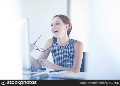 Businesswoman laughing at desk