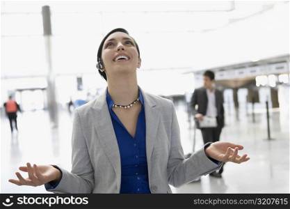Businesswoman laughing in a hands free device at an airport lounge