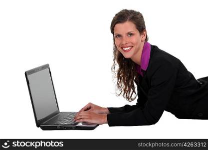 Businesswoman laying on the floor with her laptop.