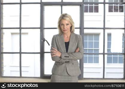Businesswoman leaning against a window sill