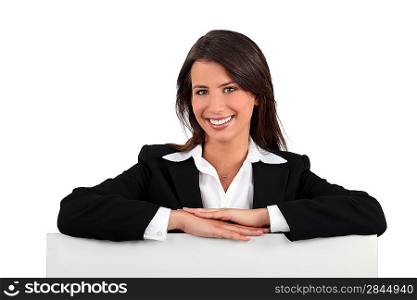 Businesswoman leaning on a board