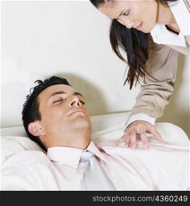 Businesswoman looking at a businessman sleeping in an armchair