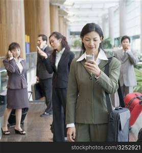 Businesswoman looking at a mobile phone at an airport