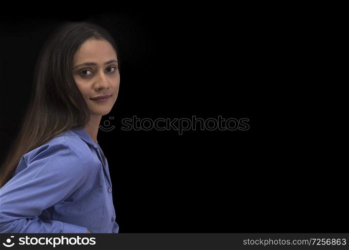 Businesswoman looking at camera over black background