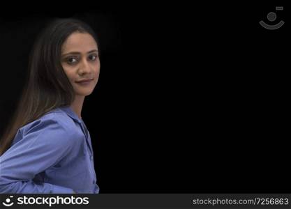 Businesswoman looking at camera over black background