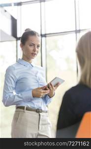 Businesswoman looking at colleague during meeting in office