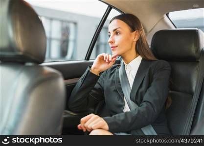 businesswoman looking through window while traveling by car