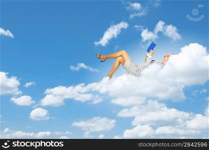 Businesswoman lying on clouds