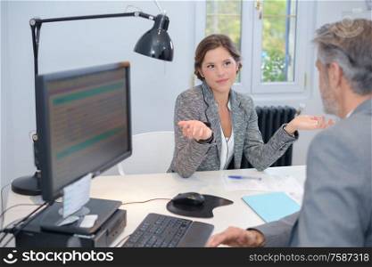 Businesswoman making questioning gesture to male colleague