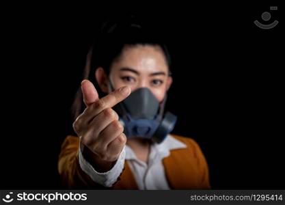 Businesswoman of young Asia woman putting on a respirator N95 mask to protect from airborne respiratory diseases as the flu covid-19 coronavirus PM2.5 dust and smog, Women is hand sign mini heart