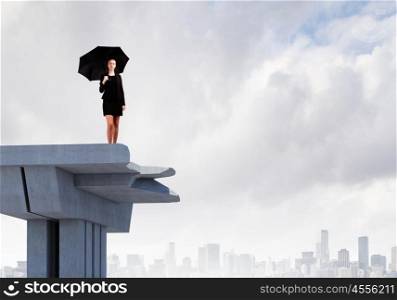 Businesswoman on bridge. Image of businesswoman standing at the edge of bridge. Risk concept