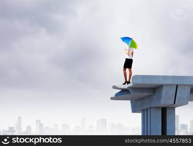 Businesswoman on bridge. Image of businesswoman standing at the edge of bridge. Risk concept