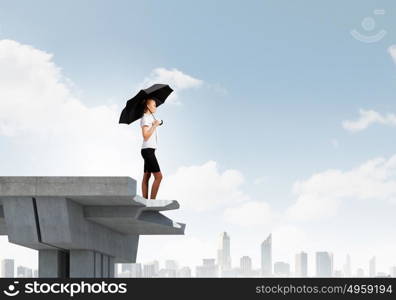 Businesswoman on bridge. Image of businesswoman standing at the edge of bridge. Risk concept