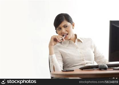 Businesswoman on call while looking at computer