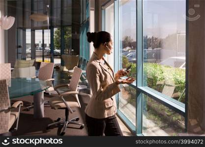 Businesswoman on cell phone in meeting room