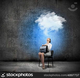 Businesswoman on chair. Image of young businesswoman sitting in chair holding suitcase