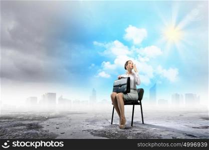 Businesswoman on chair. Image of young businesswoman sitting in chair holding suitcase