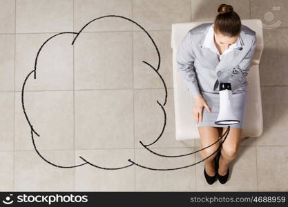 Businesswoman on chair. Top view of young businesswoman with megaphone sitting on chair