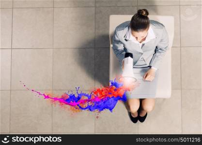 Businesswoman on chair. Top view of young businesswoman with megaphone sitting on chair