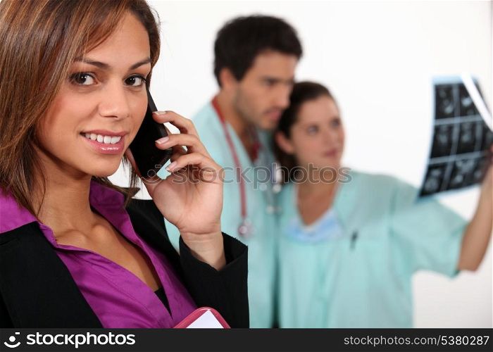 Businesswoman on phone and carers observing an x-ray