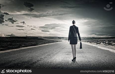 Businesswoman on road. Rear view of businesswoman standing on road