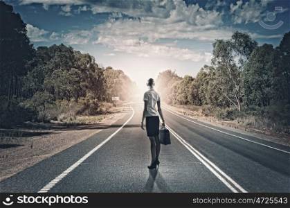 Businesswoman on road. Rear view of businesswoman standing on road