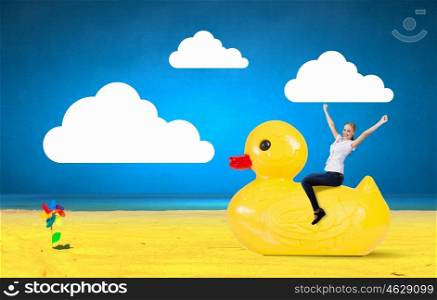 Businesswoman on rubber duck. Young happy businesswoman riding yellow rubber duck