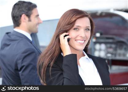 businesswoman on the phone and businessman in the background