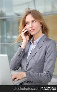 Businesswoman on the phone in front of modern building