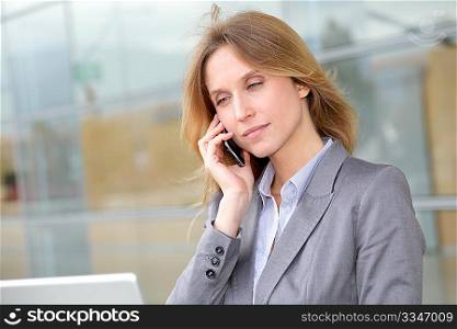 Businesswoman on the phone in front of modern building