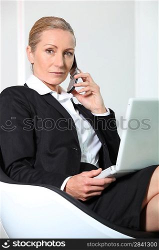 Businesswoman on the phone with laptop.