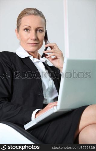 Businesswoman on the phone with laptop.