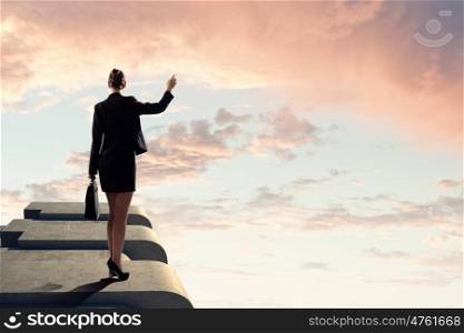 Businesswoman on top of building. Image of young businesswoman standing on top of building