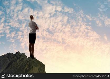 Businesswoman on top of hill. Image of businesswoman standing on top of hill